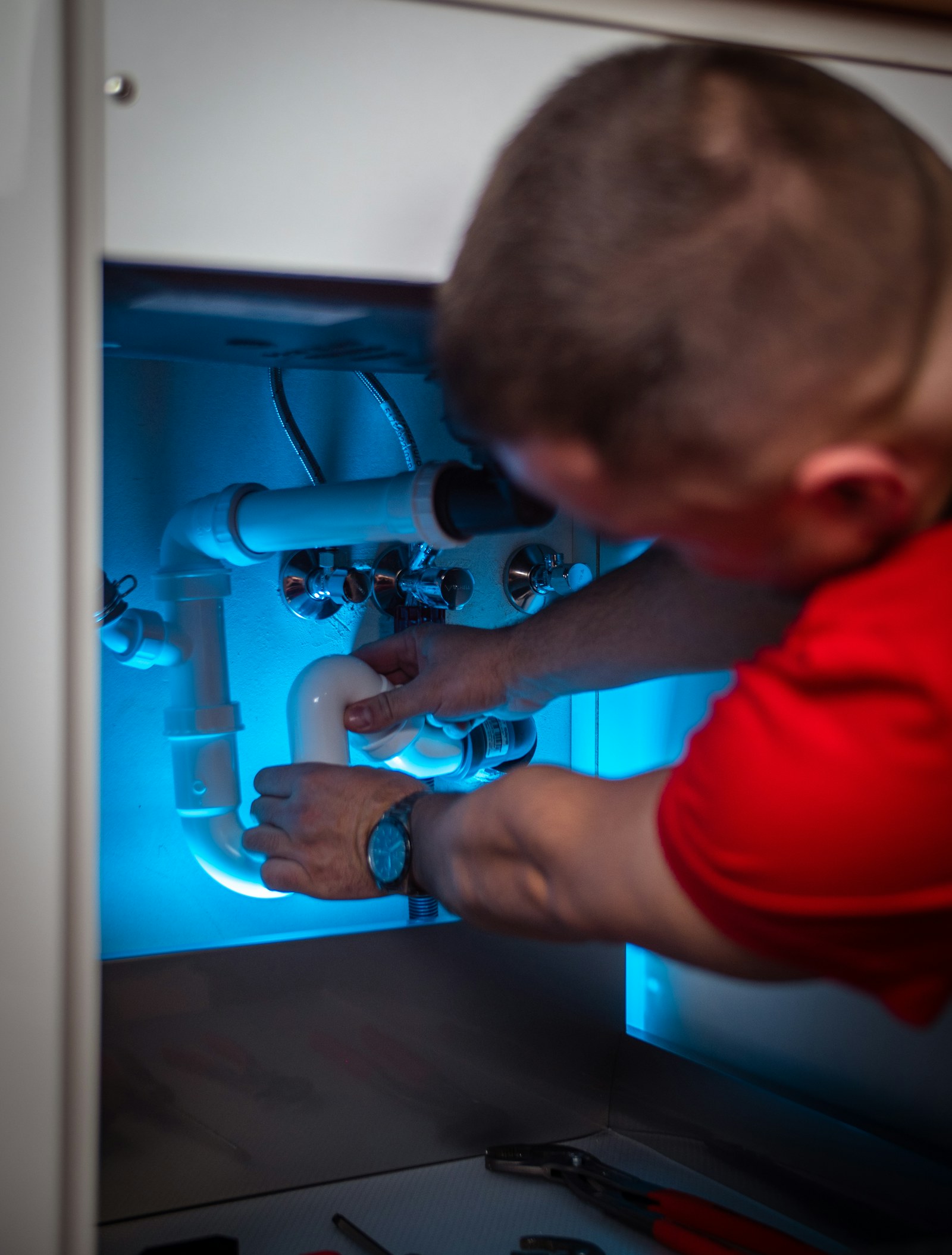 A close view of plumbing connections and household water fittings